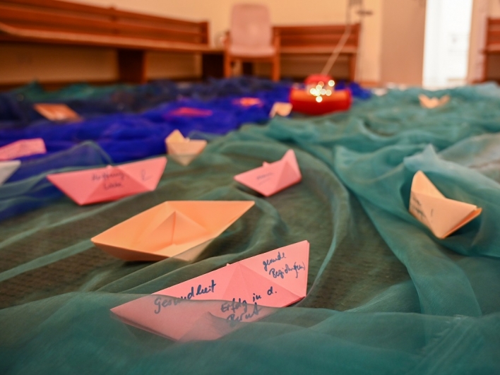 Botschaftan auf kleinen Papierbooten in der evangelischen Kapelle
