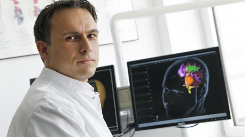 Prof. Sandro Krieg vor Computer-Bildschirm sitzend Prof. Sandro Krieg vor Computer-Bildschirm sitzend