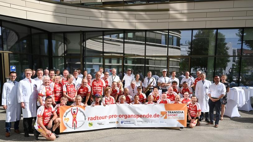 Teilnehmer der Radtour-pro-Organspende ein Banner haltend, Gruppenbild  