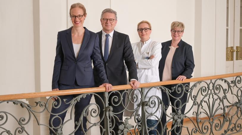 von links Marie le Claire, Dr. Martin Siess, Prof. Stephanie E. Combs und Silke Großmann hinter einem Geländer stehend von links Marie le Claire, Dr. Martin Siess, Prof. Stephanie E. Combs und Silke Großmann hinter einem Geländer stehend