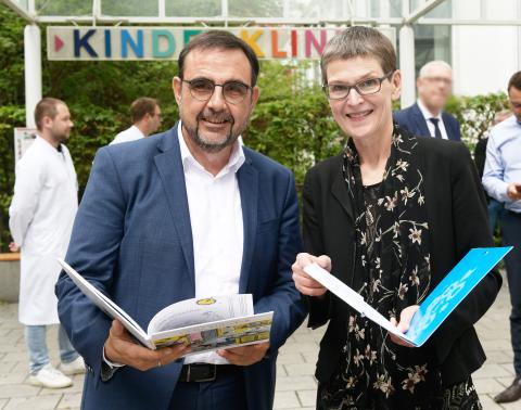 Bayerns Gesundheitsminister Klaus Holetschek mit Professor Uta Behrends schauen in die Kamera