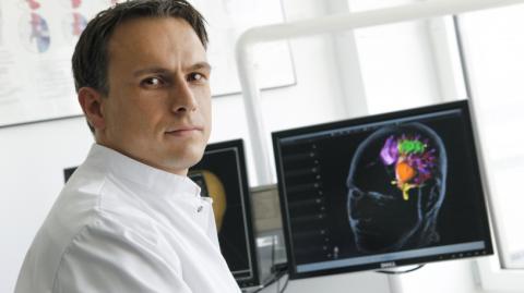 Prof. Sandro Krieg vor Computer-Bildschirm sitzend