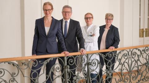 von links Marie le Claire, Dr. Martin Siess, Prof. Stephanie E. Combs und Silke Großmann hinter einem Geländer stehend