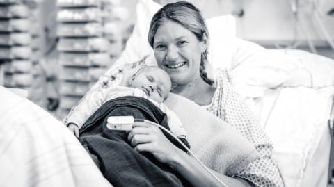 Mutter mit Neugeborenen im Krankenbett